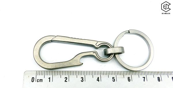 Karabiner Titan mit Öse und Schlüsselring mit Linial auf weissem Hintergrund